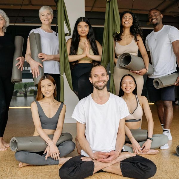 Diverse group of people smiling during a yoga class.